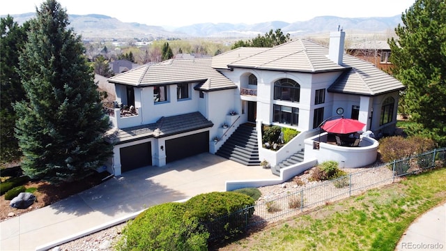 6961 Salvia St, Arvada, CO 80007 - view of front of property with stucco siding, an attached garage, stairway, and a mountain view