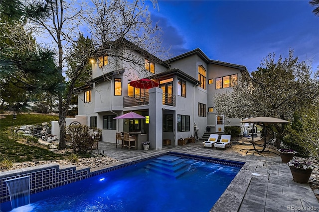 6961 Salvia St, Arvada, CO 80007 - rear view of property with a balcony, a patio, stucco siding, and an outdoor pool
