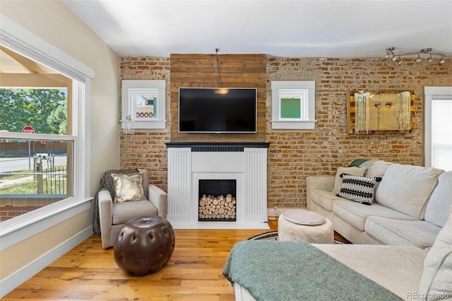 1753 W 36th Ave, Denver, CO 80211 - living area featuring wood finished floors, brick wall, and a fireplace with flush hearth