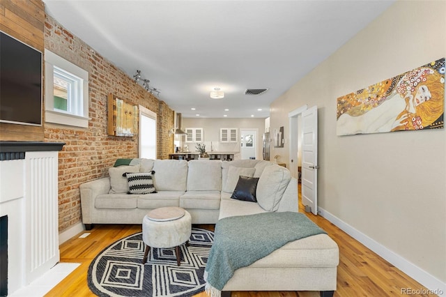 1753 W 36th Ave, Denver, CO 80211 - living area with wood finished floors, a fireplace with flush hearth, and brick wall