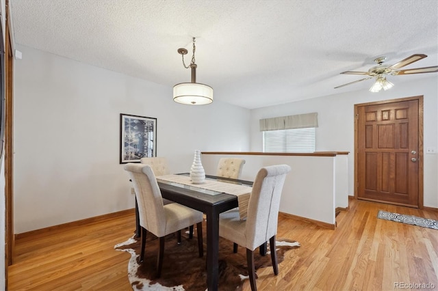 dining space featuring a textured ceiling, light wood finished floors, a ceiling fan, and baseboards