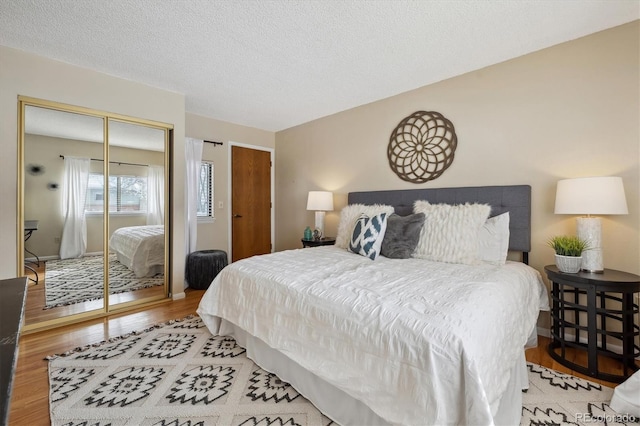 bedroom with light wood-style flooring and a textured ceiling