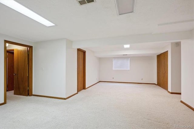 empty room with baseboards, visible vents, and light colored carpet