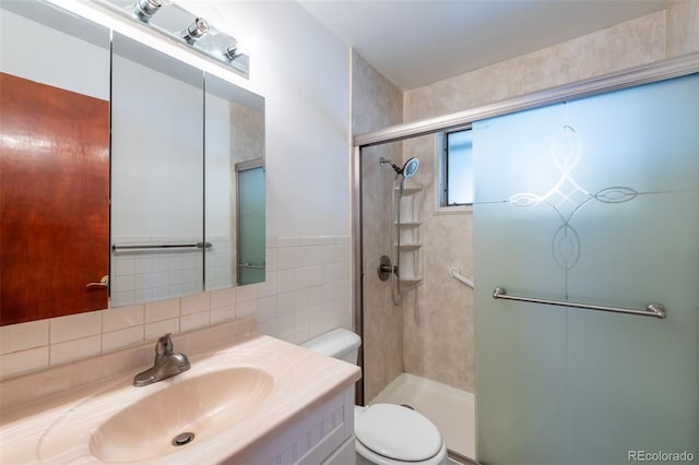 bathroom featuring backsplash, vanity, a shower with door, tile walls, and toilet