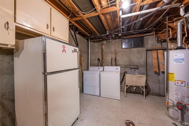 basement featuring sink, washer and dryer, gas water heater, and white refrigerator