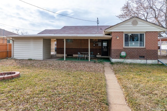 back of house featuring a fire pit, a yard, and a patio