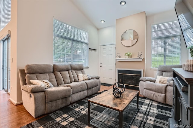 6839 Zenobia St Unit 3, Westminster, CO 80030 - living room featuring high vaulted ceiling, wood finished floors, a glass covered fireplace, baseboards, and recessed lighting