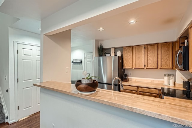6839 Zenobia St Unit 3, Westminster, CO 80030 - kitchen with appliances with stainless steel finishes, butcher block counters, recessed lighting, brown cabinetry, and dark wood-style floors
