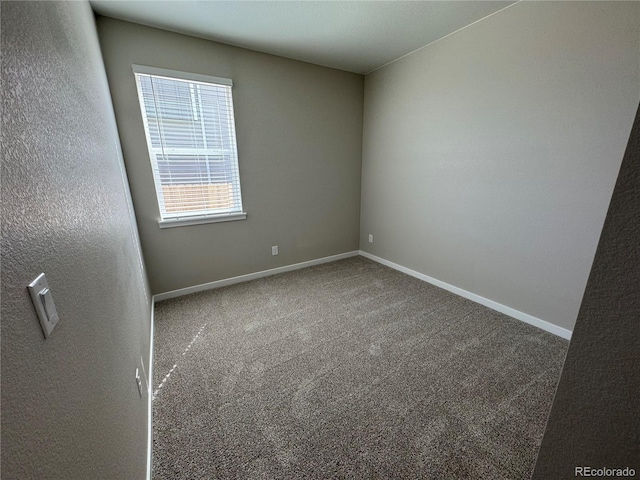 spare room with baseboards and carpet flooring