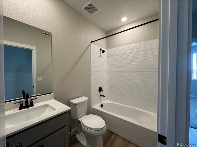 full bath with visible vents, toilet, wood finished floors,  shower combination, and vanity