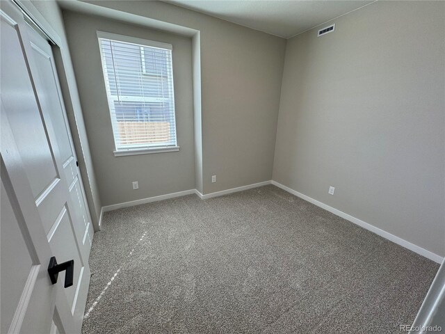 unfurnished bedroom featuring carpet flooring, baseboards, visible vents, and a closet