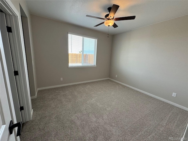 carpeted spare room with a ceiling fan, baseboards, and a textured ceiling