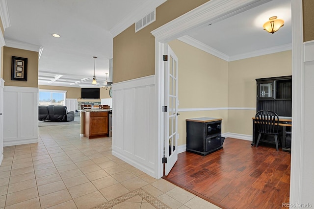 hallway featuring light tile patterned flooring and ornamental molding