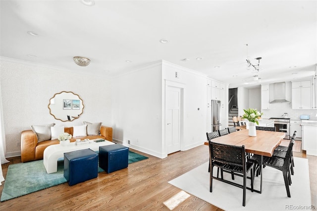 dining space with light wood-type flooring and crown molding