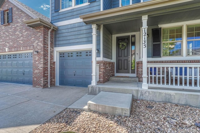 view of exterior entry with a garage and a porch