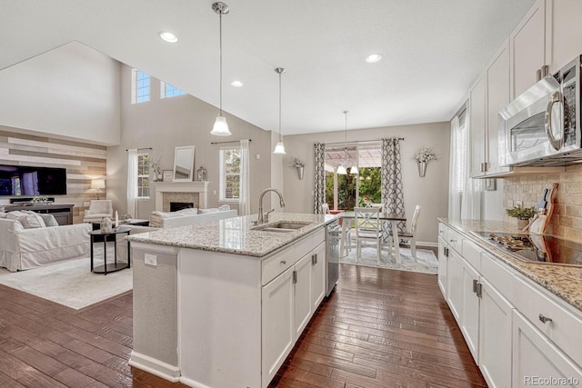 kitchen with light stone counters, appliances with stainless steel finishes, sink, and white cabinets