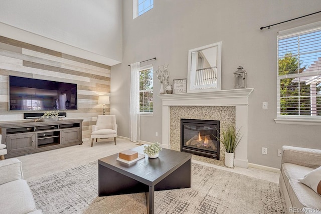 carpeted living room with a tile fireplace and a high ceiling