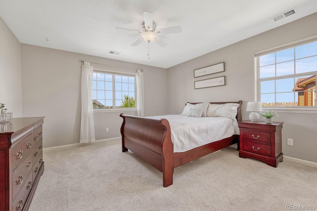 bedroom featuring multiple windows, light carpet, and ceiling fan