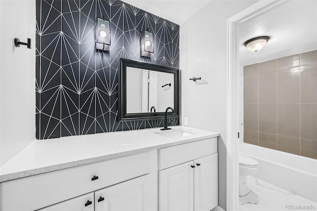 bathroom featuring tile walls, backsplash, vanity, and toilet