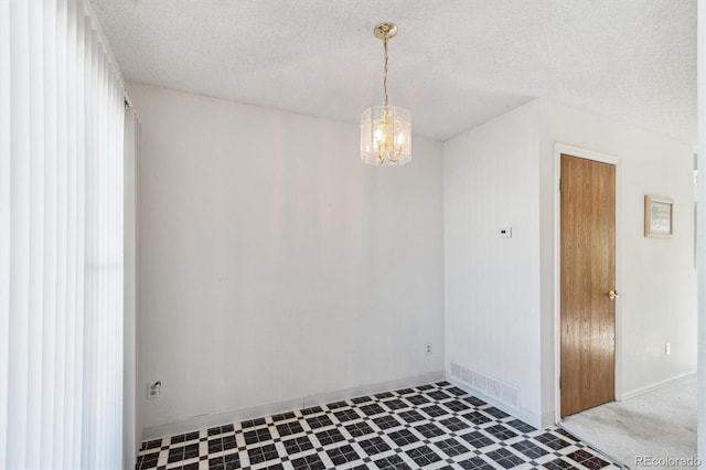 892 Summer Dr Unit 15B, Highlands Ranch, CO 80126 - unfurnished dining area featuring tile patterned floors, a chandelier, a textured ceiling, and baseboards