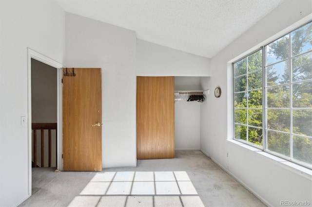 892 Summer Dr Unit 15B, Highlands Ranch, CO 80126 - unfurnished bedroom featuring carpet, lofted ceiling, multiple windows, a closet, and a textured ceiling