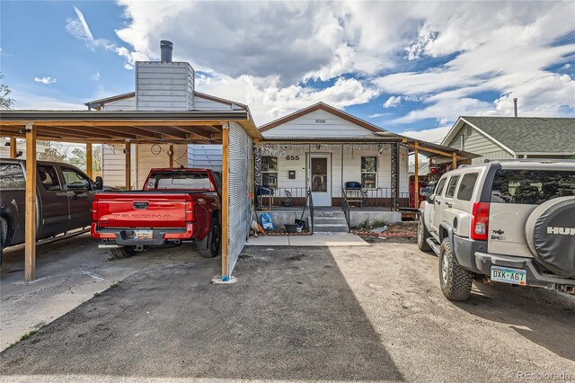 655 S Perry St, Denver, CO 80219 - view of front of house featuring a carport, a chimney, and covered porch