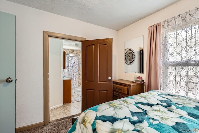 655 S Perry St, Denver, CO 80219 - carpeted bedroom featuring ensuite bath, baseboards, tile patterned flooring, and a textured ceiling