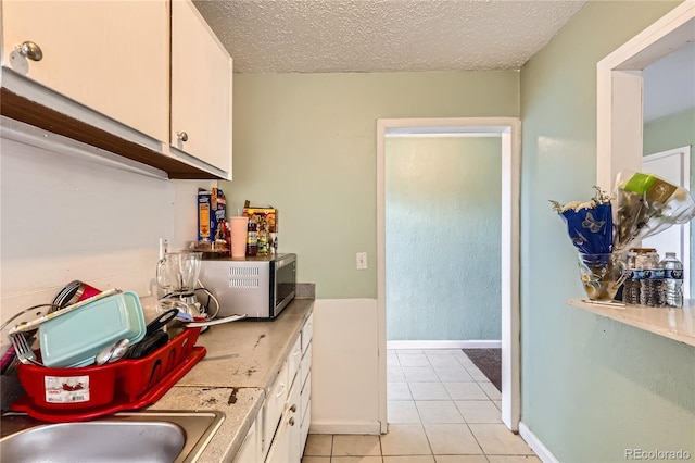 655 S Perry St, Denver, CO 80219 - interior space featuring a textured ceiling, light tile patterned floors, baseboards, and a sink
