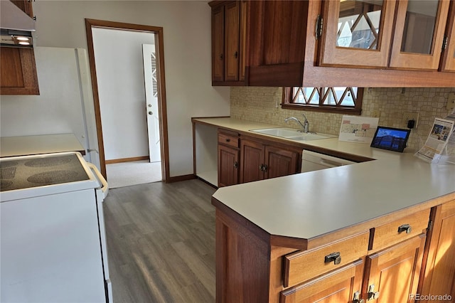 kitchen featuring exhaust hood, kitchen peninsula, dark hardwood / wood-style floors, white appliances, and sink