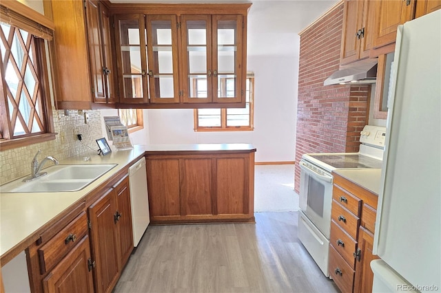 kitchen featuring white appliances, sink, kitchen peninsula, light hardwood / wood-style flooring, and range hood