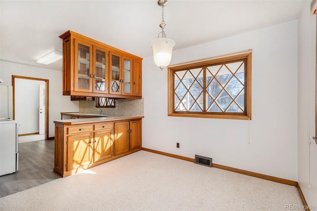 kitchen with light carpet, decorative backsplash, and pendant lighting