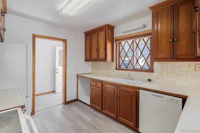 kitchen with decorative backsplash, sink, white appliances, and light hardwood / wood-style flooring