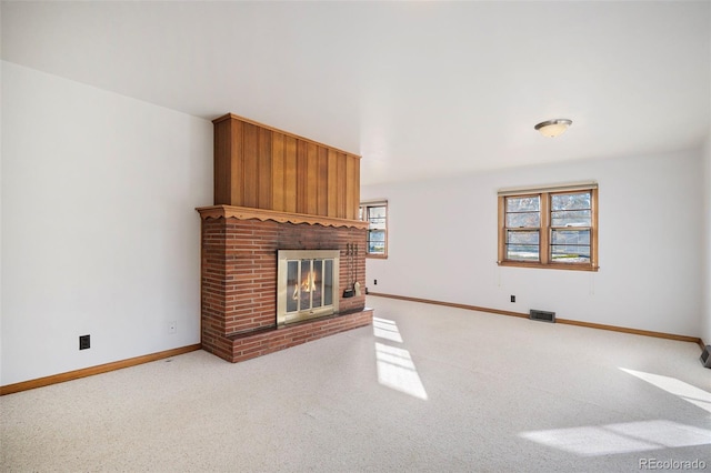 unfurnished living room with light colored carpet and a fireplace