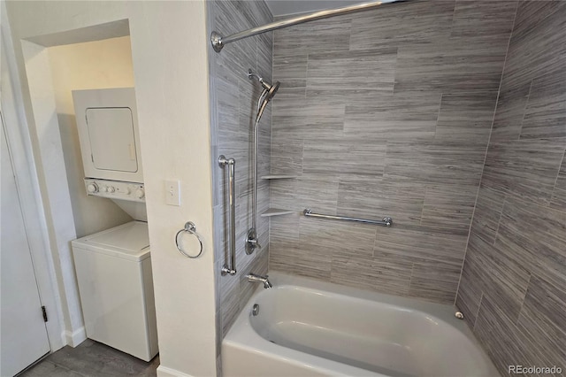 bathroom with stacked washer / drying machine and tiled shower / bath