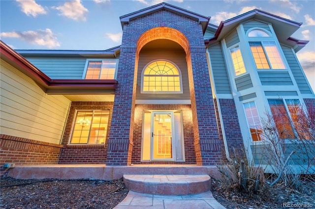 doorway to property with brick siding