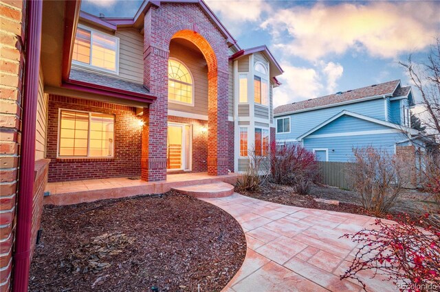 exterior space featuring fence and brick siding