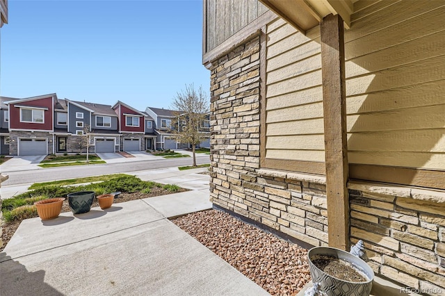view of home's exterior with stone siding and a residential view
