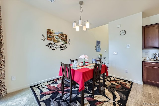 dining space with baseboards and a notable chandelier