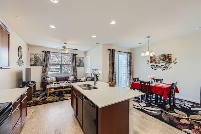 kitchen featuring black / electric stove, light countertops, dishwashing machine, a sink, and light wood-style flooring
