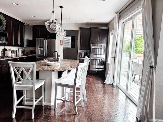 15468 W 50th Pl, Golden, CO 80403 - kitchen with stainless steel appliances, plenty of natural light, a kitchen bar, and a kitchen island with sink