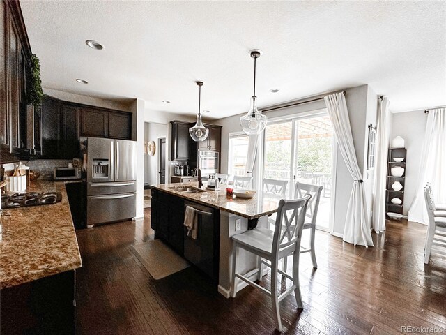 15468 W 50th Pl, Golden, CO 80403 - kitchen featuring stainless steel fridge with ice dispenser, dishwashing machine, dark wood-type flooring, a kitchen bar, and a center island with sink