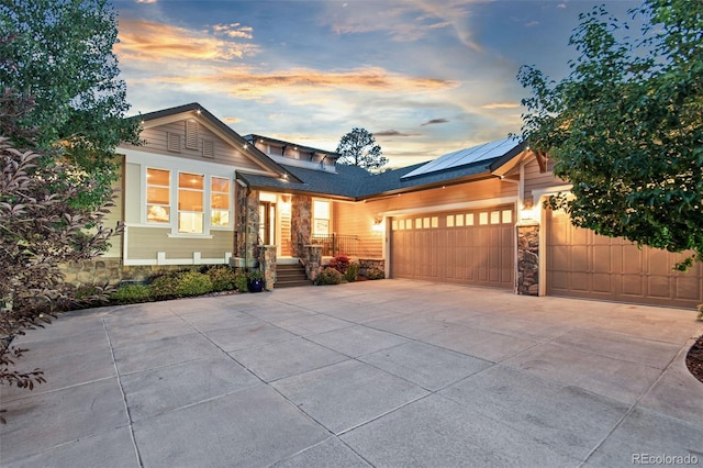 24906 E Geddes Cir, Aurora, CO 80016 - view of front facade with stone siding, driveway, and roof mounted solar panels
