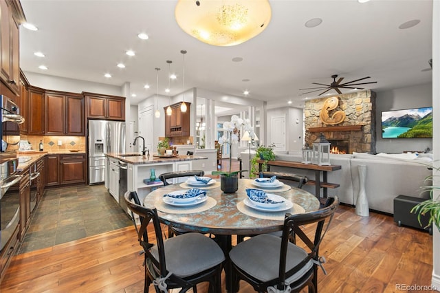 24906 E Geddes Cir, Aurora, CO 80016 - dining space featuring a ceiling fan, recessed lighting, a fireplace, and dark wood-style floors