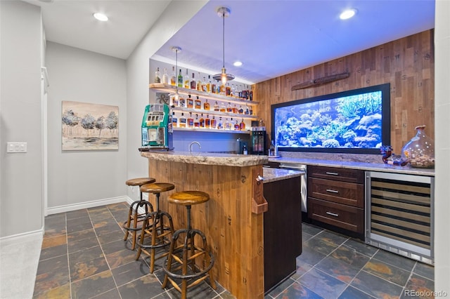 24906 E Geddes Cir, Aurora, CO 80016 - indoor wet bar with wine cooler, dark stone finish flooring, wooden walls, hanging light fixtures, and recessed lighting
