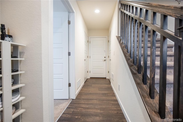 hallway with dark wood-style floors, stairs, visible vents, and baseboards