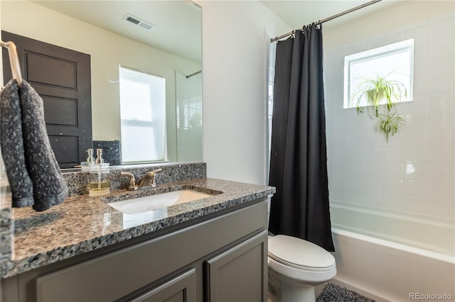 full bathroom with vanity, shower / bath combination with curtain, visible vents, and a healthy amount of sunlight