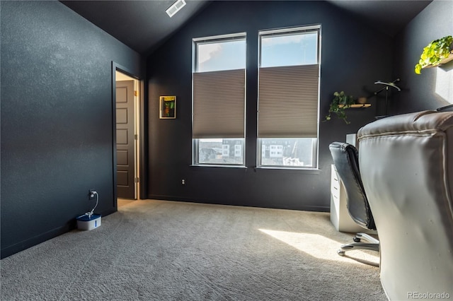 unfurnished office with lofted ceiling, carpet floors, a textured wall, and visible vents