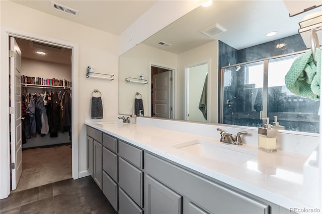 bathroom with visible vents, a sink, and double vanity