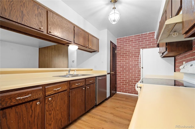 kitchen featuring dishwasher, sink, brick wall, pendant lighting, and range