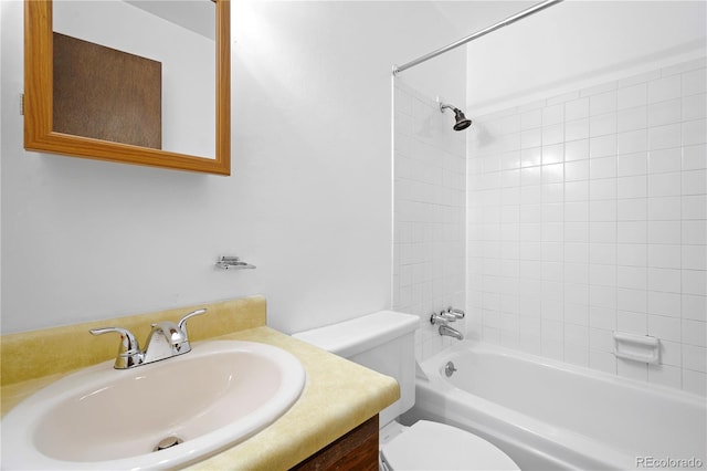 full bathroom with tiled shower / bath, vanity, and toilet